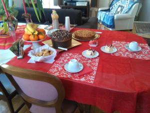 a table with a red table cloth with food on it at La Castellese in Aci Castello