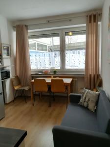 a living room with a couch and a table with chairs at Apartments Nikol - Ludwigshafen in Ludwigshafen am Rhein