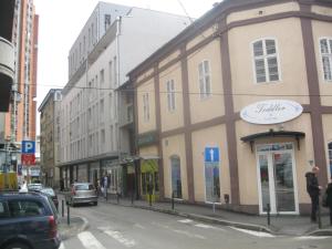 a building on a city street with cars parked on the street at Apartment Centar in Užice