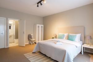 a bedroom with a large white bed and a bathroom at Hotel Franky in Blankenberge