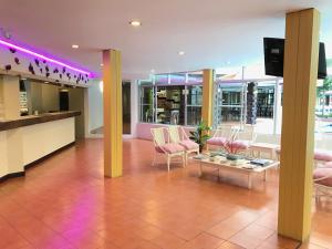 芭達雅中心的住宿－芭堤雅九點酒店，大堂设有粉红色的椅子和一张桌子,位于大楼内