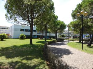 un parco con alberi e un marciapiede e un edificio di Villa Bianca a Bibione