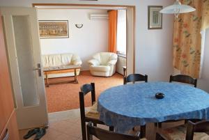 a living room with a blue table and chairs at Apartments & Rooms BARBARA in Umag
