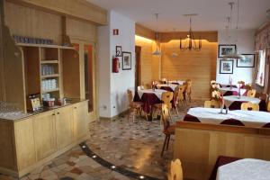 un restaurante con mesas y sillas en una habitación en Hotel Haberl en Tarvisio