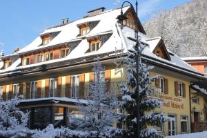 ein Gebäude mit einem schneebedeckten Dach in der Unterkunft Hotel Haberl in Tarvis