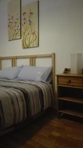 CastelloteにあるLa Troyaのベッドルーム1室(ベッド1台、絵画2点が飾られたナイトスタンド付)