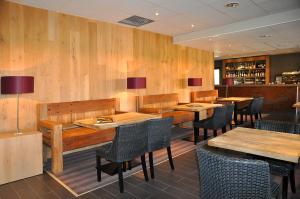 a restaurant with wooden walls and tables and chairs at Castel de Vergio in Albertacce