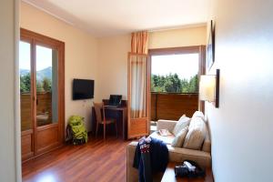 a living room with a couch and a desk with a television at Castel de Vergio in Albertacce
