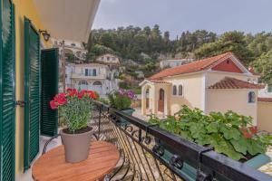 a balcony with a table with flowers on it at Semeli Apartment in Zakynthos Town