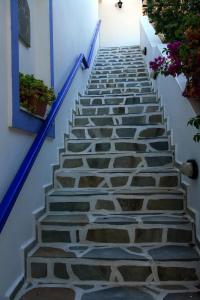 uma escada de pedra com corrimão azul e flores em Syros Atlantis em Vári