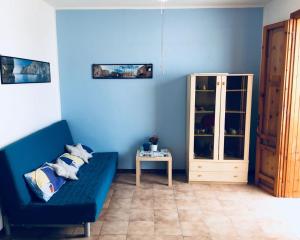 a living room with a blue couch and a table at Casa Vacanza a due passi dal mare e dalla Poesia in Torre dell'Orso