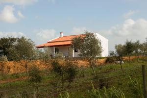 a white house with an orange roof on a hill at Monte Quinta Verde in Ferreira do Alentejo