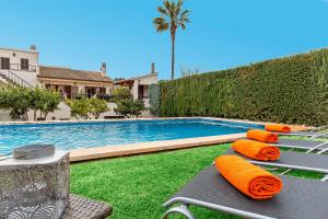 a swimming pool with orange life pillows next to at Ca Na Rosa in El Port de la Selva