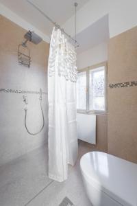 a bathroom with a shower and a tub and a sink at Kafka Apartment with bridge view in Prague