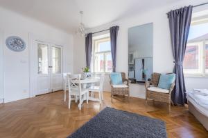 a living room with a dining room table and chairs at Kafka Apartment with bridge view in Prague