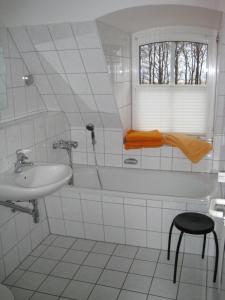 a bathroom with a sink and a tub and a window at Bernsteinhaus Düne 10 in Zingst
