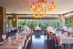 a dining room with tables and chairs and a chandelier at Castel de Vergio in Albertacce