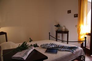 a room with a bed with a table and a book at SARDINIA RE - Casa Cipro in Castelsardo