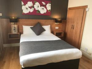 una camera da letto con un letto e un dipinto sul muro di Whites Hotel a Newcastle upon Tyne