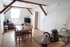 eine Küche und ein Wohnzimmer mit Tisch und Stühlen in der Unterkunft Schwaben Apartment in Oberboihingen