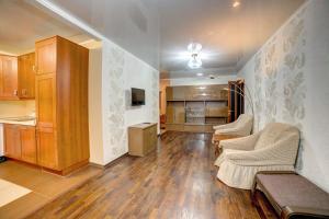 a large living room with wooden floors and a kitchen at Apartament on Sovetskaya lux in Tomsk