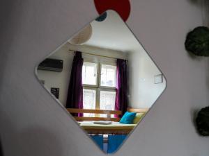 a bedroom with a window and a bed with purple curtains at Hostel El Diablo in Belgrade