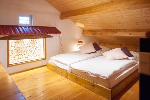 duże łóżko w pokoju z drewnianym sufitem w obiekcie "Domaine de la Mance" - Gite-Maison de vacances w mieście Vitrey