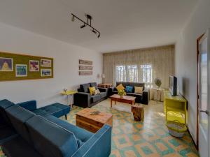 ein Wohnzimmer mit blauen Sofas und einem TV in der Unterkunft Casa Arbós in Arbeca