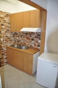 a kitchen with a sink and a brick wall at Hotel Filoxenia in Ligia