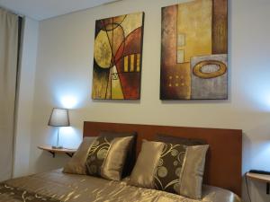 ポンタ・デルガダにあるCenter City Garden Apartmentのベッドルーム1室(壁に絵画3点が飾られたベッド1台付)