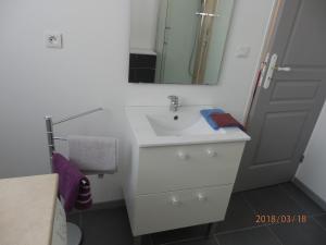 a bathroom with a white sink and a mirror at location vacances in Linguizzetta +23 photos