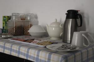 a table with a tray of food and a coffee pot at Strand Meadows B&B in Gaborone