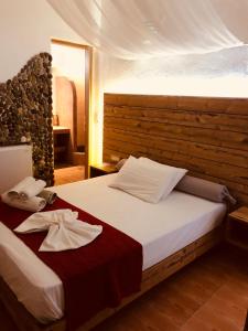 a bedroom with a large bed with a wooden headboard at Villa Livadaros in Karterados