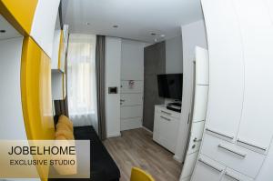een klein appartement met een woonkamer en een televisie bij JobelHome Castle District Apartments in Boedapest