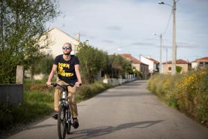 Um homem a andar de bicicleta numa rua em Cerca Design House no Fund�o