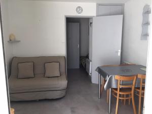 ein Wohnzimmer mit einem Sofa und einem Tisch in der Unterkunft studio parking 5 min de la plage in La Grande-Motte