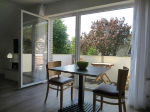 Un comedor con mesa y sillas y una gran ventana. en dat geele hus 5, en Büsum 15 fotos más