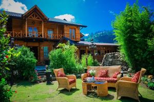 a patio with chairs and a table in front of a house at Queenswood Cottage in Nuwara Eliya