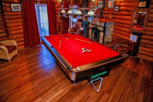 a red pool table in a room with a fireplace at Queenswood Cottage in Nuwara Eliya