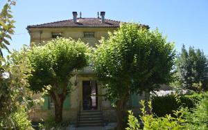 una casa vieja con árboles delante de ella en Maison Carrée - Chalabre, en Chalabre