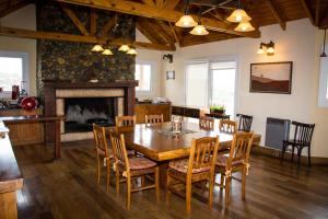 a dining room with a table and chairs and a fireplace at Estancia La Estela in Lago Viedma