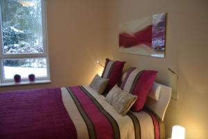 een slaapkamer met een groot bed met rode kussens bij la terrasse du lac in Vielsalm