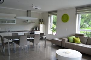 a kitchen and living room with a couch and a table at la terrasse du lac in Vielsalm