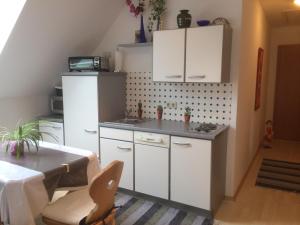 a kitchen with white cabinets and a table at Ferienwohnungen Urbanitsch in Klöch