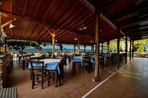 a restaurant with tables and chairs on a patio at Hotel Vlassis in Stomio