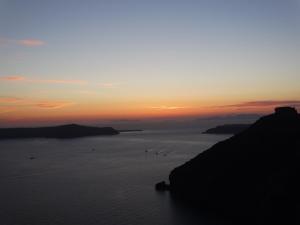 a group of birds in the water at sunset at Yposkafo Suites - Studio - Santorini in Fira