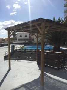 une pergola en bois installée à côté d'une piscine dans l'établissement Cozy Apartment, à Candelaria
