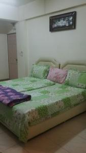 a bed with pillows on it in a room at Vanlisut Hotel Ngamwongwan in Nonthaburi