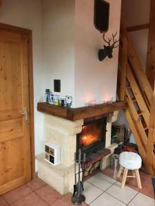 a living room with a stone fireplace with a tv at Chal'Oz 4 stars in Oz