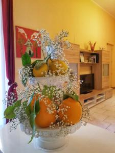 un'esposizione di arance e fiori su un tavolo di Apartment Inn ad Aci Castello